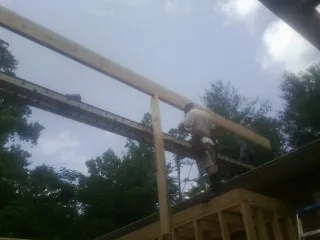 Carpenter setting a ridge beam over a new addition frame — Ice Dam Removal by Roofing Brothers in Paxtonville