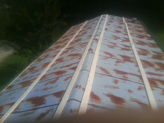 Rusted metal roof panels with new wood purlins before replacement — Storm Damage Roof Repair in Paxtonville by Roofing Brothers
