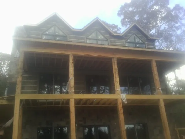 Dormers and porch framing on a large log home under construction — Roof Coating work by our crew in Paxtonville