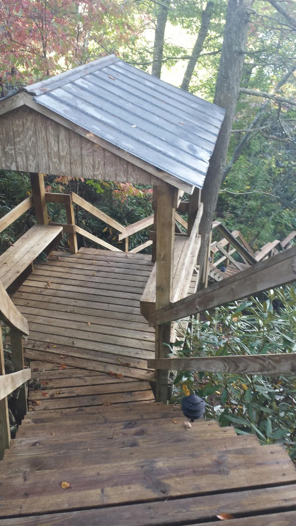 Metal roofed shelter over wooden steps on a wooded walkway — Skylight Repair & Installation work by our crew in Paxtonville