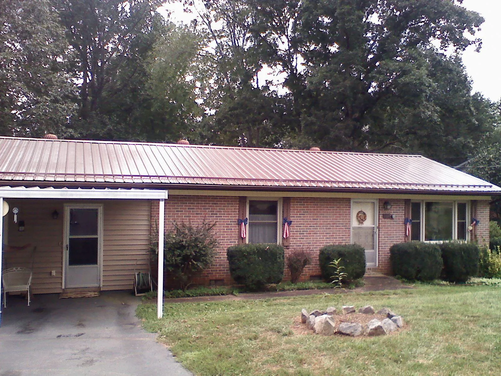 Bronze metal roof and carport on a brick ranch home — Roof Repair work by our crew in Paxtonville
